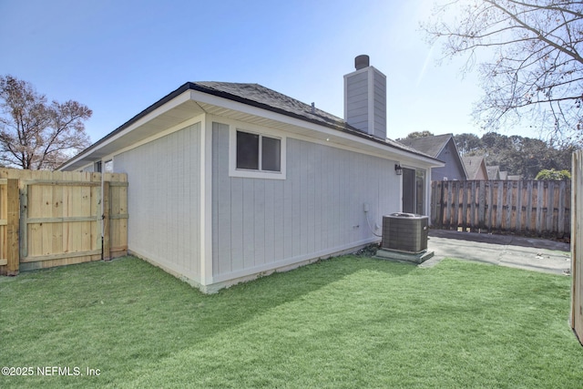 back of property with a lawn and central air condition unit