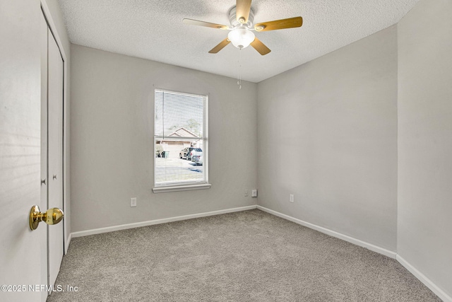 carpeted spare room with a textured ceiling and ceiling fan