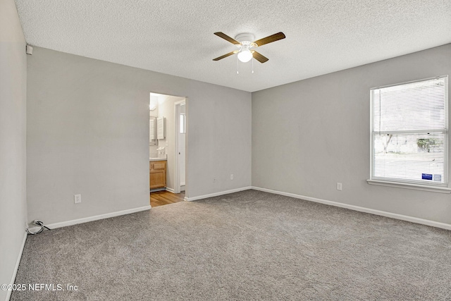 carpeted spare room with ceiling fan and a textured ceiling