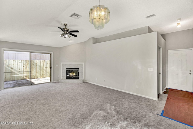 unfurnished living room with ceiling fan with notable chandelier, a fireplace, a textured ceiling, and carpet