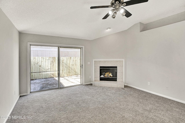 unfurnished living room with ceiling fan, a fireplace, carpet floors, and a textured ceiling