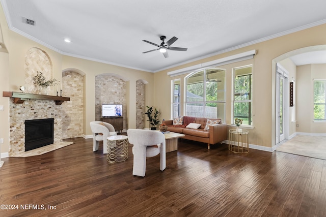 living room with a fireplace, dark hardwood / wood-style floors, ceiling fan, and plenty of natural light