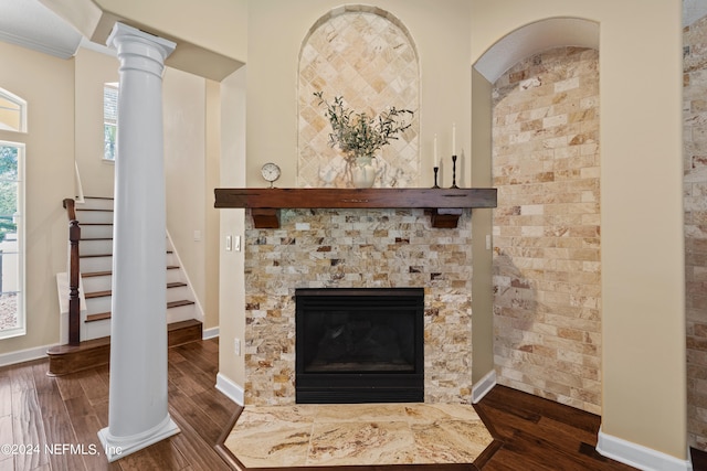 details featuring ornate columns, a fireplace, and hardwood / wood-style floors