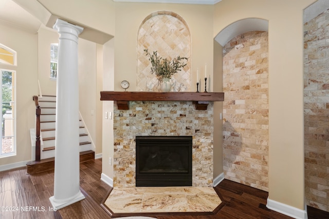 interior details with ornamental molding, hardwood / wood-style floors, decorative columns, and a fireplace