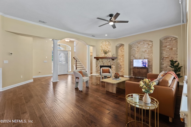 living room featuring a fireplace, ornate columns, crown molding, ceiling fan, and dark hardwood / wood-style floors