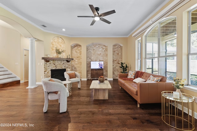 living room featuring ceiling fan, decorative columns, dark hardwood / wood-style flooring, and a tile fireplace