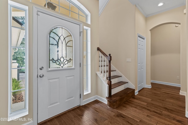 entrance foyer featuring crown molding and dark wood-type flooring