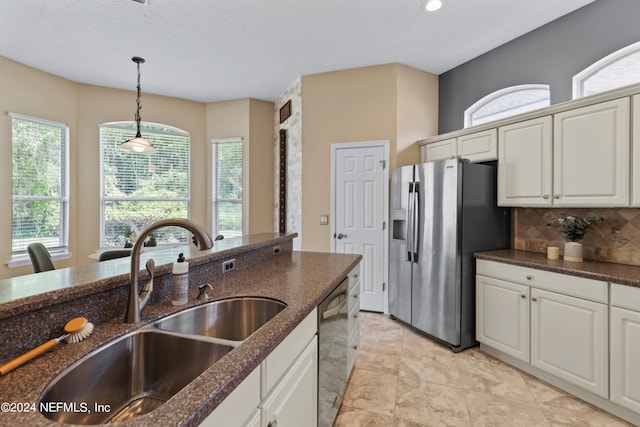 kitchen featuring stainless steel appliances, white cabinets, a healthy amount of sunlight, and sink