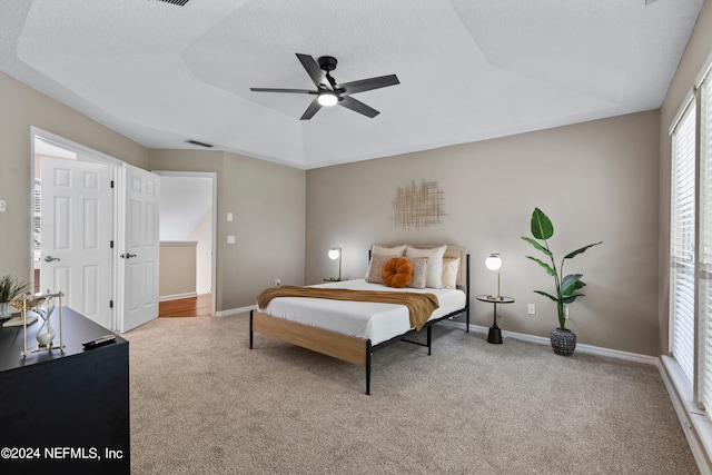 bedroom with light carpet, ceiling fan, and a textured ceiling