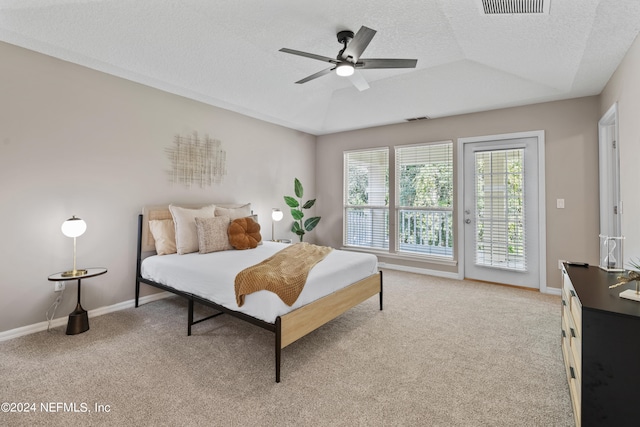 carpeted bedroom with a textured ceiling, vaulted ceiling, ceiling fan, and access to exterior