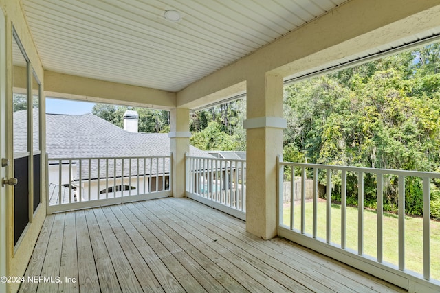 wooden deck featuring a lawn