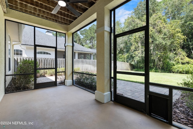 unfurnished sunroom featuring ceiling fan