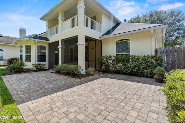 view of front of property featuring a balcony and a patio area