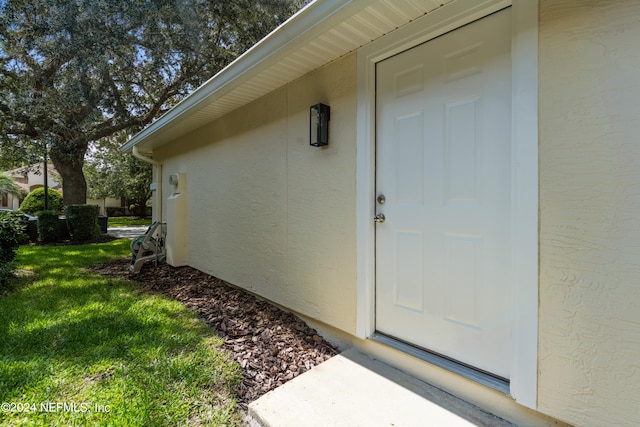 doorway to property with a yard