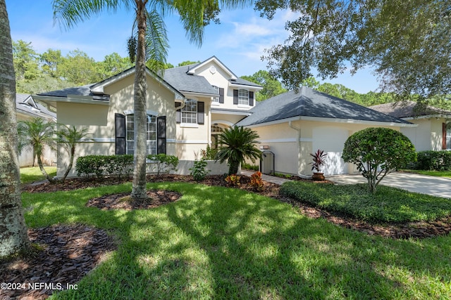 view of front of property featuring a front lawn and a garage