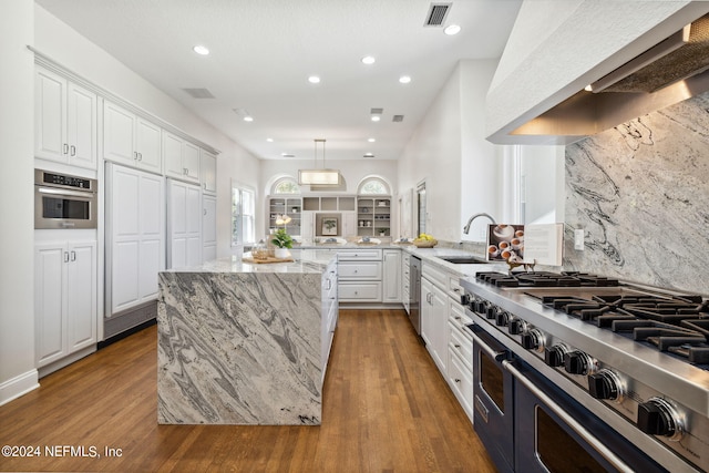 kitchen with light hardwood / wood-style flooring, white cabinetry, kitchen peninsula, and appliances with stainless steel finishes