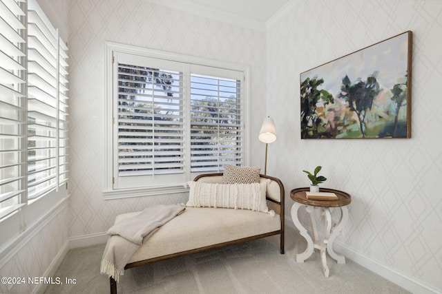 sitting room with ornamental molding and carpet flooring