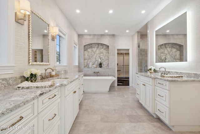 bathroom featuring tile walls, shower with separate bathtub, and vanity