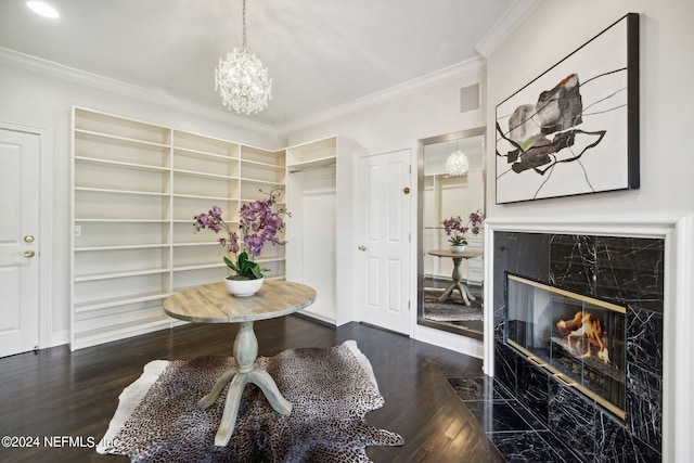 interior space with a high end fireplace, a chandelier, dark wood-type flooring, ornamental molding, and built in features