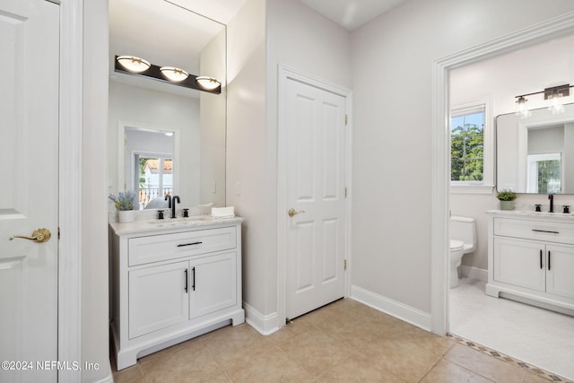 bathroom with vanity, toilet, and tile patterned floors