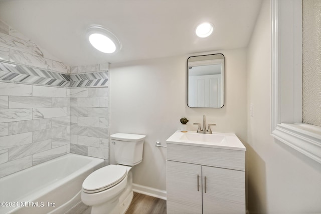 full bathroom featuring tiled shower / bath, vanity, hardwood / wood-style floors, and toilet