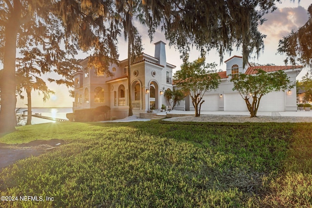 view of front of house featuring a water view and a yard