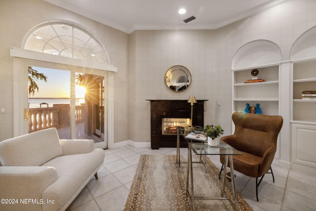 sitting room featuring a healthy amount of sunlight, a multi sided fireplace, light tile patterned floors, and crown molding