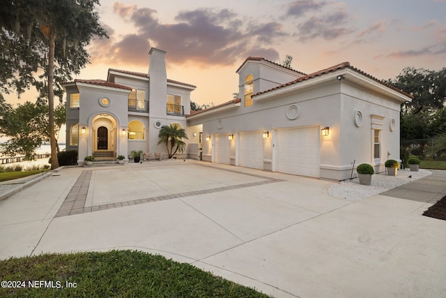 mediterranean / spanish-style home with a balcony and a garage