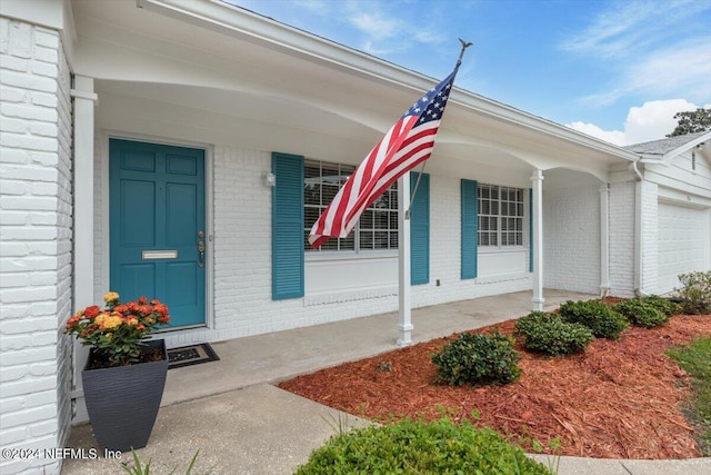 entrance to property featuring covered porch and a garage