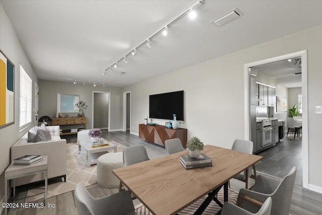 dining area featuring track lighting and wood-type flooring