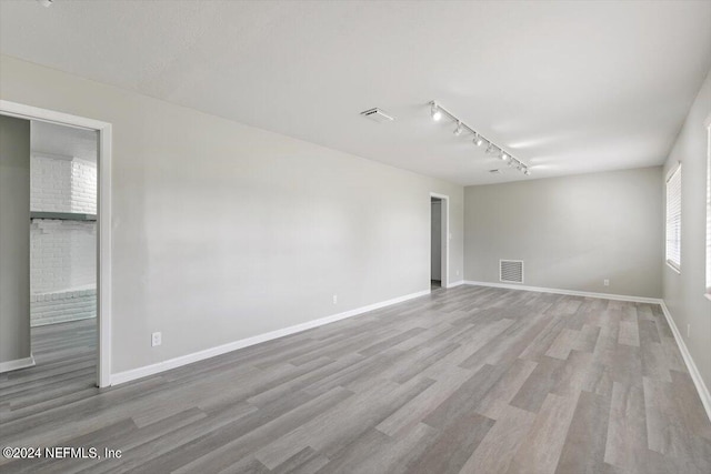 spare room with light wood-style floors, visible vents, and baseboards