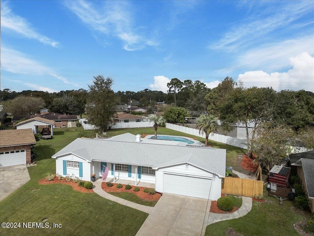 ranch-style house with concrete driveway, a front lawn, an attached garage, and fence