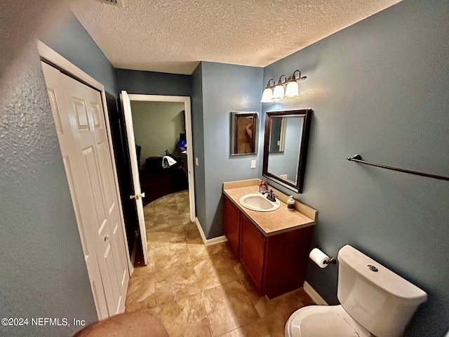 bathroom with vanity, a textured ceiling, and toilet