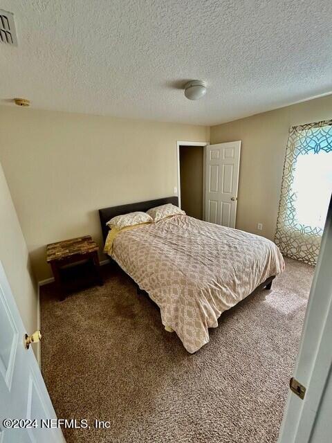 carpeted bedroom with a textured ceiling