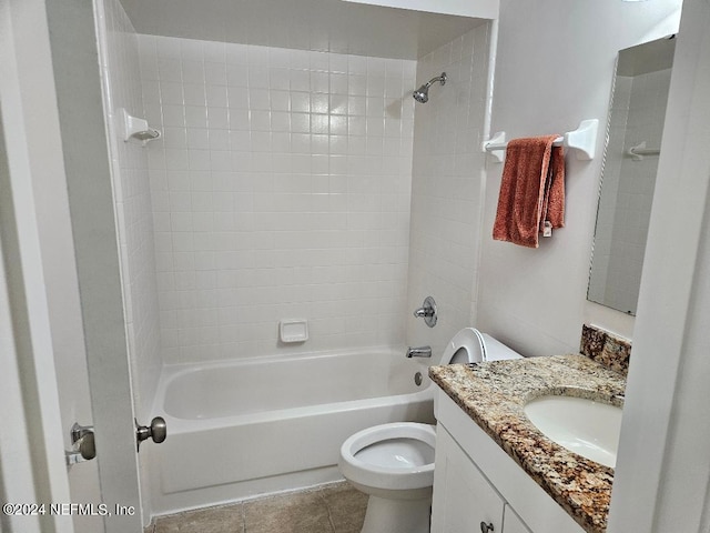 full bathroom featuring tiled shower / bath, vanity, toilet, and tile patterned flooring