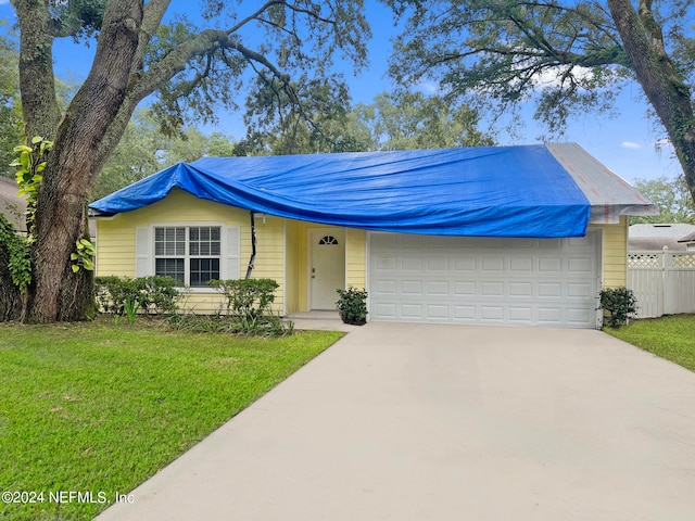 ranch-style home with a front lawn and a garage