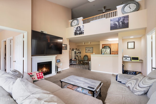 living room featuring a high ceiling, ceiling fan, and carpet floors