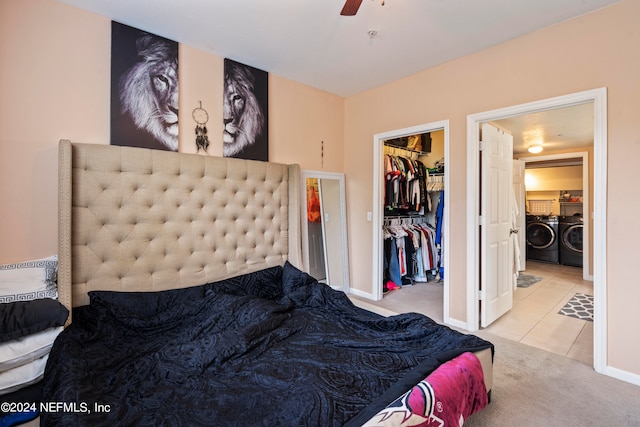 bedroom with light carpet, separate washer and dryer, ceiling fan, a closet, and a spacious closet