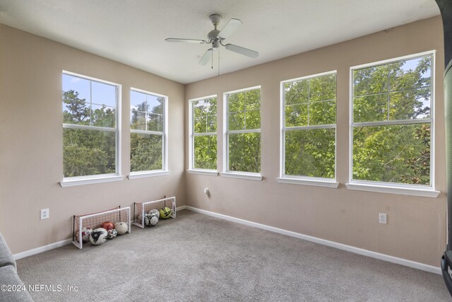 carpeted spare room featuring ceiling fan