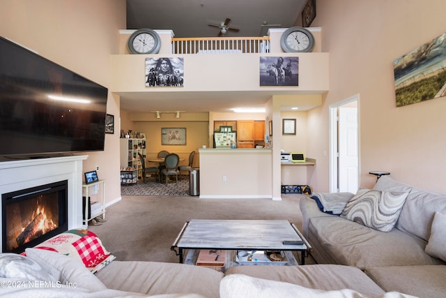 living room featuring a high ceiling, ceiling fan, and carpet floors