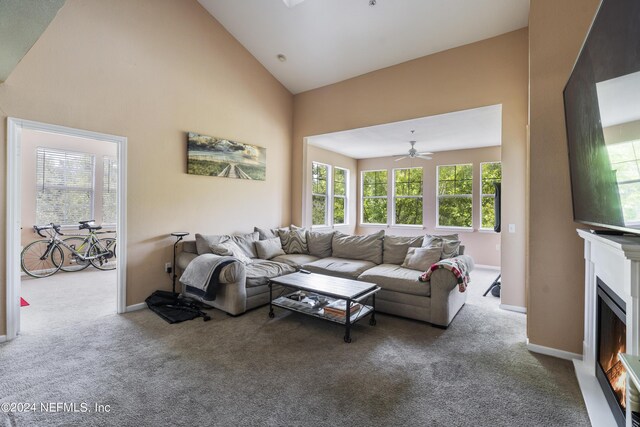 carpeted living room featuring ceiling fan and high vaulted ceiling