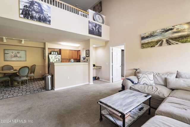 carpeted living room featuring a high ceiling