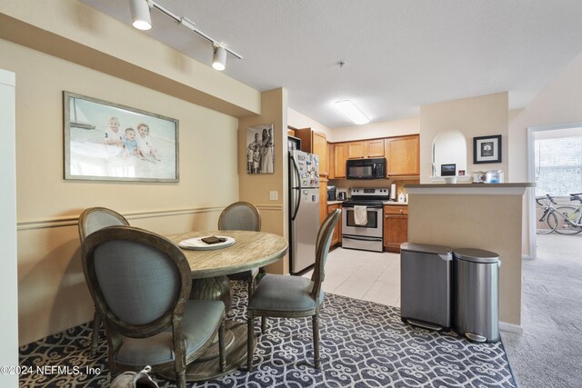 dining room with light carpet and track lighting