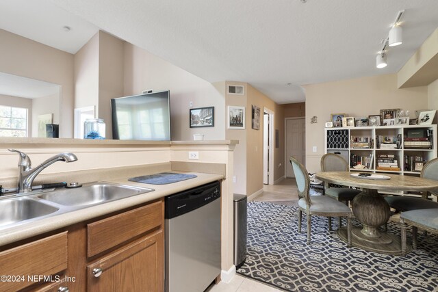 kitchen with dishwasher, sink, and light tile patterned flooring