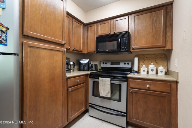 kitchen featuring appliances with stainless steel finishes and light tile patterned flooring