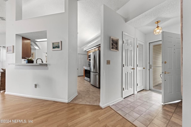 entryway featuring a textured ceiling and light hardwood / wood-style flooring