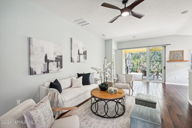 living room featuring lofted ceiling, ceiling fan, hardwood / wood-style flooring, and a textured ceiling