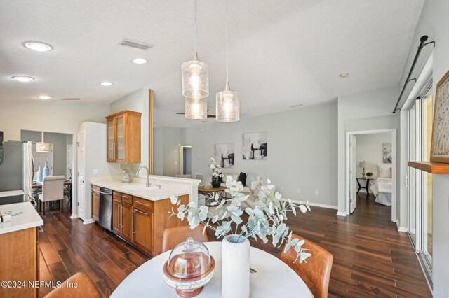 kitchen with hanging light fixtures, a textured ceiling, appliances with stainless steel finishes, dark hardwood / wood-style floors, and vaulted ceiling