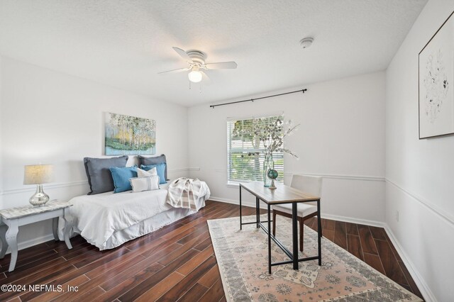 bedroom with ceiling fan, a textured ceiling, and dark hardwood / wood-style flooring