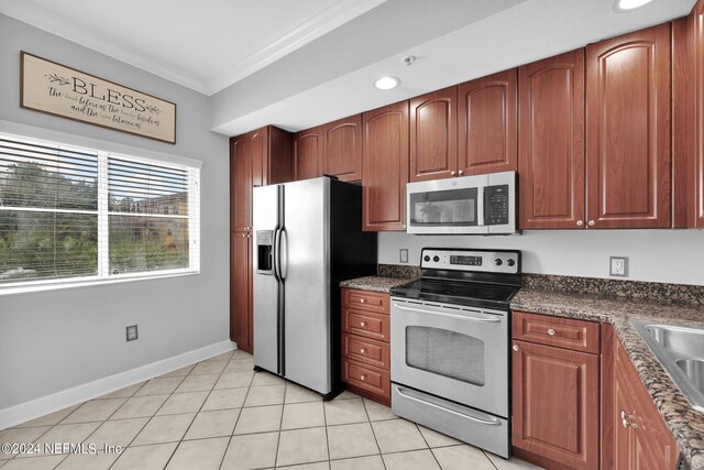 kitchen featuring light tile patterned floors, stainless steel appliances, and crown molding